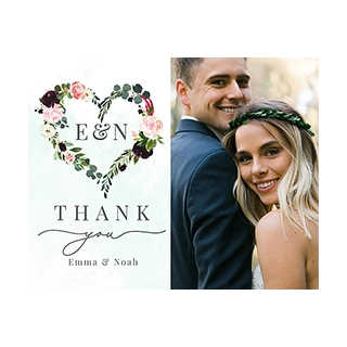 Note card sets: A split image featuring a white thank you card on the left with a watercolor floral heart wreath enclosing E & N, and text THANK you Emma & Noah, next to a smiling couple on the right, the woman wearing a green leaf headpiece.