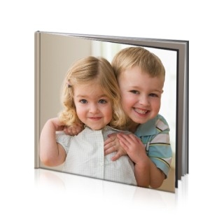 Photo Books: A square hardcover photo book with a cover photo of two smiling young siblings.
