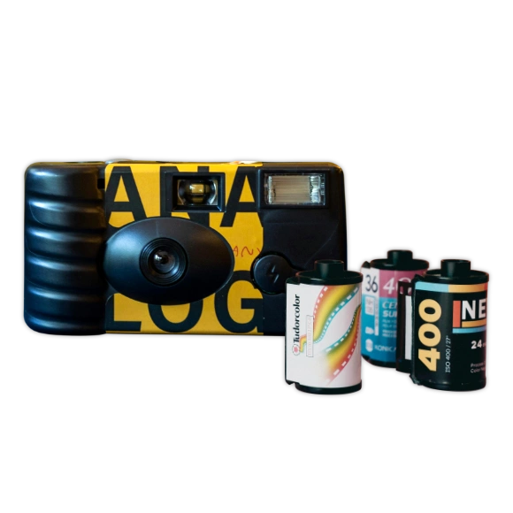 Film Processing: A yellow and black analog disposable camera with three rolls of 35mm film in front of it.