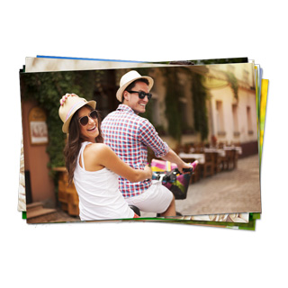 Wedding Photo Prints: A stack of photo prints with the top photo showing a happy couple riding a bike.