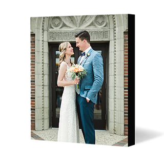 Mounted Prints: A square mounted photo print of a bride and groom standing in front of a building.