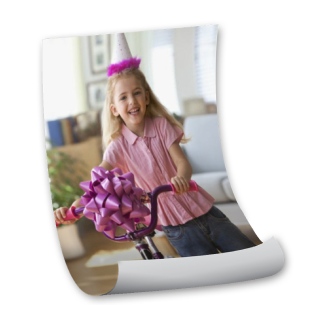 Custom Posters: A partially rolled photo poster of a girl on a new bicycle at her birthday.