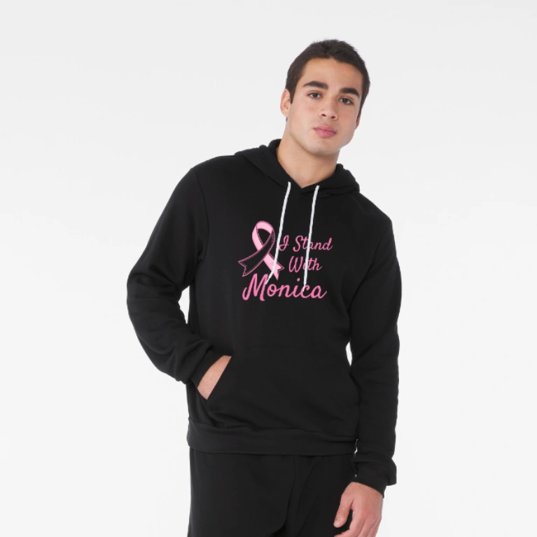 Unisex Sponge Fleece Hoodie - Black, Size L: A model wearing a black hoodie with a pink breast cancer awareness ribbon and personalized support message.
